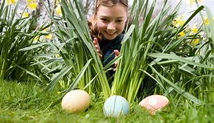 Boy finding Easter Eggs in grass